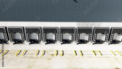 Loading bay doors and docking areas of large industrial factory. Close up aerial view. 