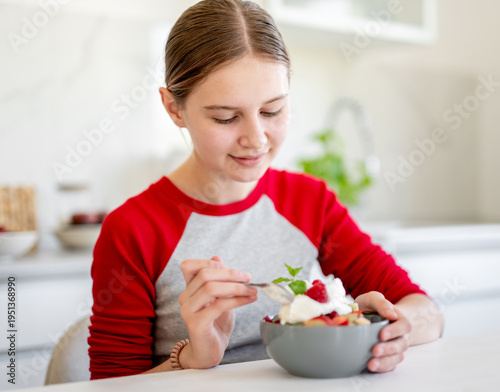 Wallpaper Mural Smiling Girl Eating Fruit Salad At Home In The Kitchen Torontodigital.ca