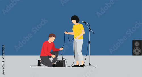 Two people set up audio equipment for a performance with a microphone and speaker
