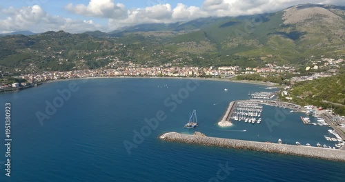 Panorama of the port of Sapri, located in the province of Salerno, Campania, Italy. In the background, the small town overlooking the bay. Aerial view of a sheltered harbor and its long breakwater.