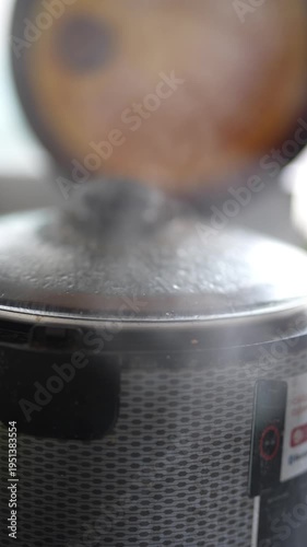 Steaming pot with glass lid simmering on kitchen stove.