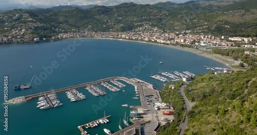 Panorama of the port of Sapri, located in the province of Salerno, Campania, Italy. In the background, the small town overlooking the bay. Aerial view of a sheltered harbor and its long breakwater.