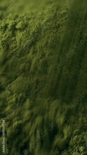 Matcha green tea powder falling down close up. Moringa, Spirulina, chlorella superfoods, vertical video format