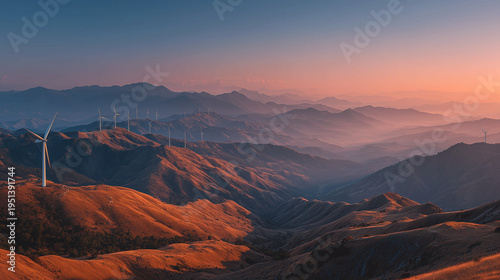 Wind turbines at sunrise on foggy hills as a clean energy concept with golden light, clear colorful sky and wide beatiful landscape