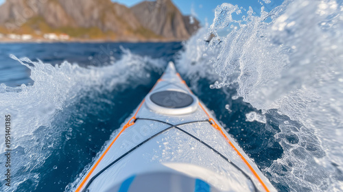 The bow of a kayak cuts through open water, raising splashes.
