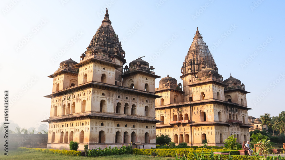 Obraz premium Golden hour view of historic Royal cenotaphs of Orchha with dramatic clouds and soft light, Madhya Pradesh, India.
