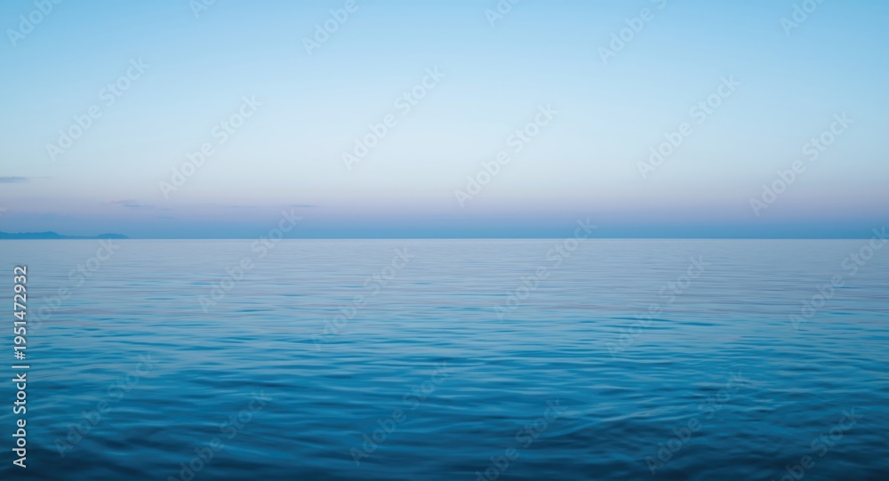 Fototapeta premium Quiet seascape at dusk with smooth ocean surface and translucent blue sky with copy space