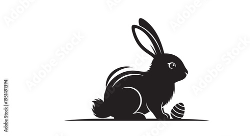 A black silhouette of a rabbit sitting next to an egg