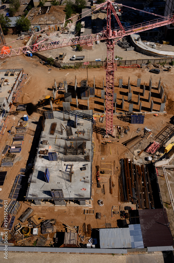 Fototapeta premium Aerial view of construction site with crane and building materials visible