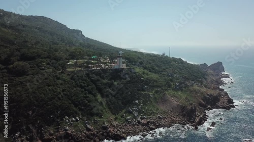 Drone aerial of Cape Spartel lighthouse on a rugged cliff overlooking the Atlantic Ocean near Tangier, showcasing dramatic coastal landscapes in northern Morocco.