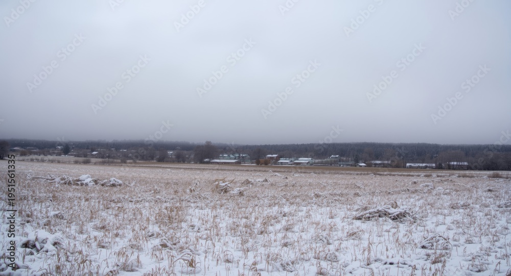Fototapeta premium Snow covered open farm field in rural setting with thick cloud layer