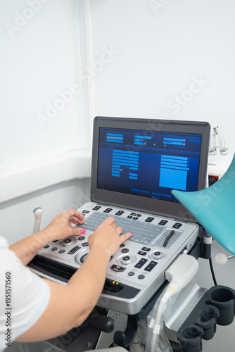 The specialist's hands work with the ultrasound machine panel