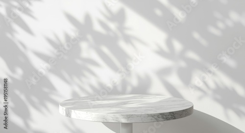 Round marble table surface with soft patterns of tree leaf shadows on a white wall background for product showcasing mockup