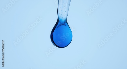Macro photograph of a perfect circle drop resembling a blue petal in glass