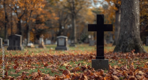 Quiet autumn graveyard scene showing granite tombstone with a black cross