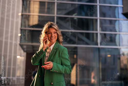 Businesswoman talking on phone outside modern office building