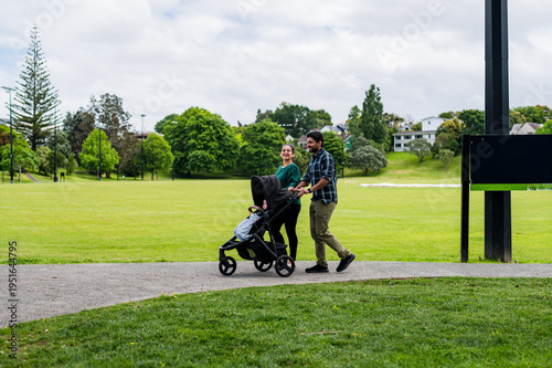 A couple pushing a pram with their child along a path in McLeod Park