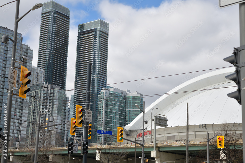 Obraz premium looking northwest to Rogers Centre, a stadium and to the west cluster of residential towers in the CityPlace area from Queens Quay W and Rees St, Toronto