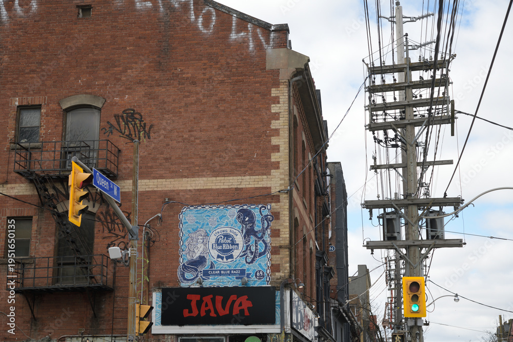Fototapeta premium historic brick building and sign of Java House with painted wall mural of 