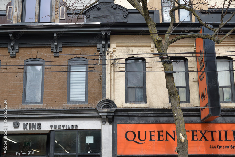 Fototapeta premium facade of buildings with signs of King Textiles (446 Queen W) and Queen Textiles Inc (444 Queen W), Toronto