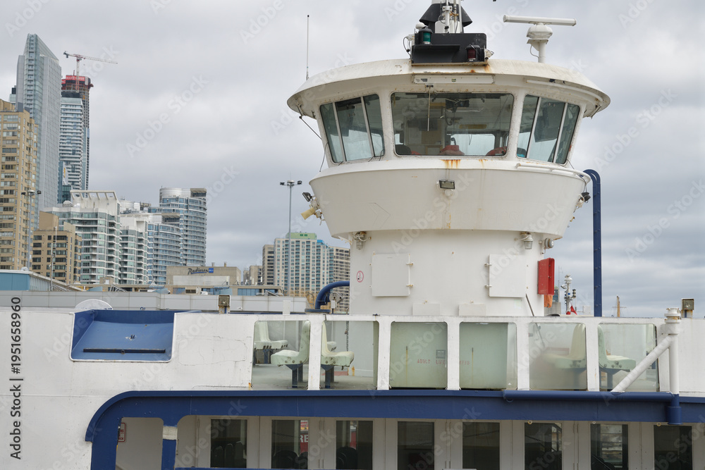 Fototapeta premium tour boat with prominent bridge structure in Toronto harbor, with view of mostly condominium complexes 