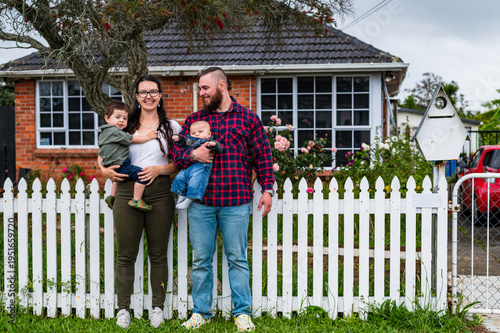 Happy family standing outside their picket fence