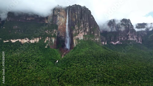 Aerial drone view of Angel Falls flowing down the cliffs of Auyan-tepui with clouds drifting across the mountains in Canaima National Park, Venezuela
