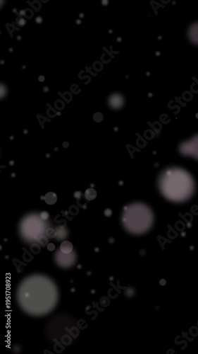 Pastel circles particles moving on dark background showing soft abstract vertical animation