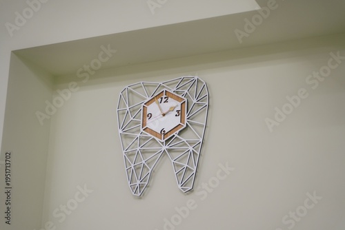 A tooth-shaped clock in a dental clinic. An interesting watch as a gift to the dentist. Stylish accessories for the dental clinic.