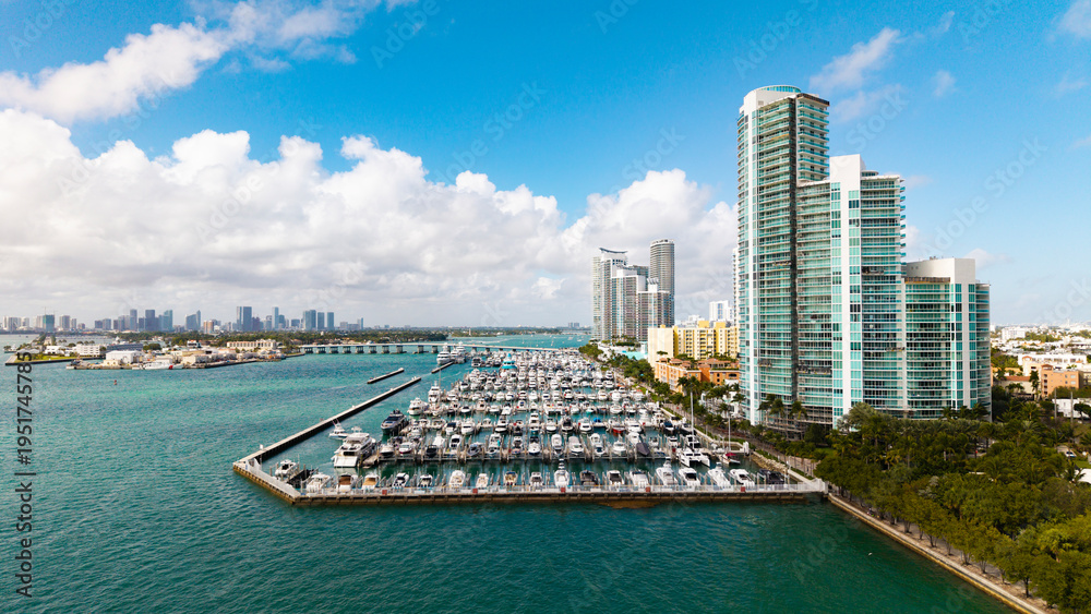 Fototapeta premium Marina Bay filled with vessels and yacht in Miami. Summer vacation scene with yachts by the oceanfront. Skyline with yachts in Miami. Florida coastline from above with boats. Boat trip in the Miami.