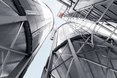 Foto Industrial silos with steel framework and skyward perspective