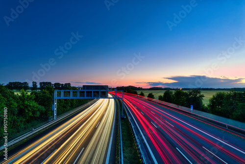 German Autobahn at Sunset with Long Exposure Light Trails and Gantry Sign