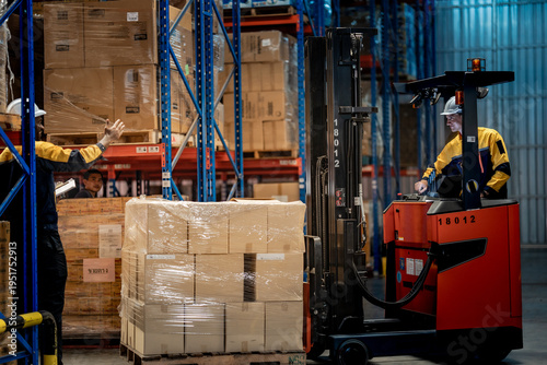 Cuadro en lienzo Caucasian male factory employee driving heavy forklift vehicle with wrapped cargo boxes
