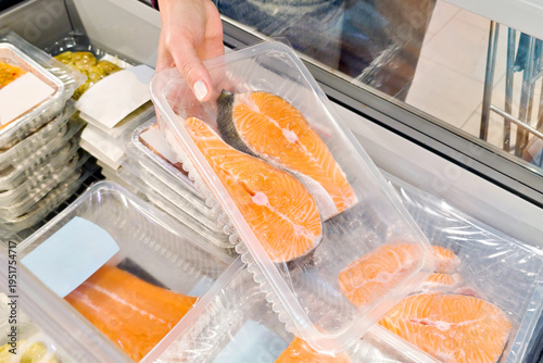 Customer Holding Packaged Salmon Steaks in Supermarket