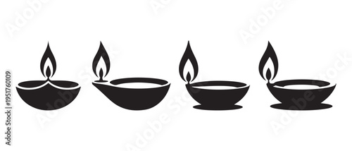 A serene arrangement of four traditional indian diyas with lit wicks on a plain white background for cultural or festive purposes.