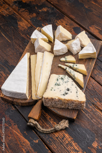 Foto Selection of creamy Brie soft Camembert and blue Roquefort displayed on a textured wooden board for an artisanal gourmet look