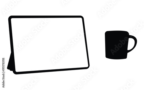 White screen tablet on stand next to a black mug on clean white surface