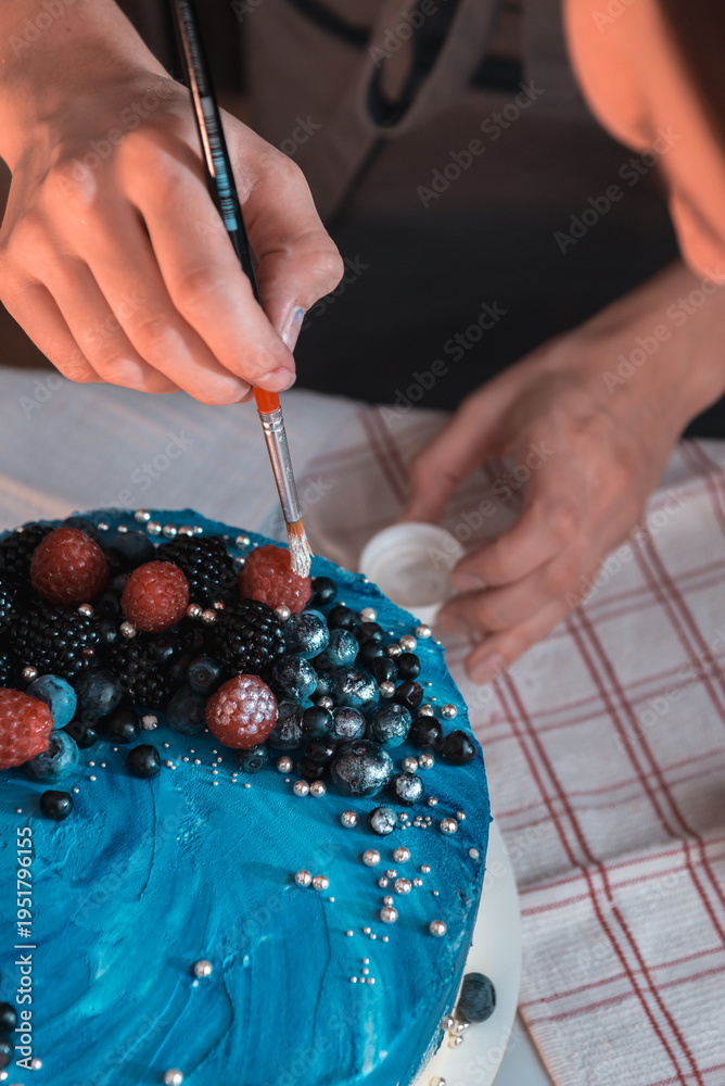 Obraz premium Hand painting edible dust on berry cake