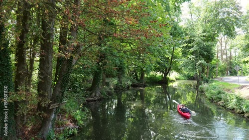 Lübbenau, Germany – Leisure kayaking on idyllic waterway between trees in the Spreewald. Suitable for sustainable tourism and recreation.