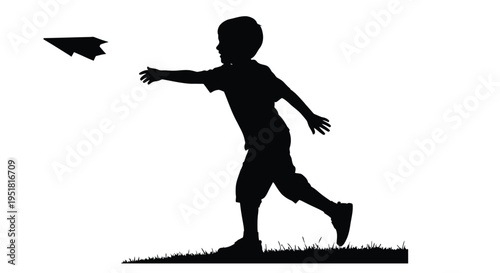 Silhouette of a young boy launching a paper airplane outdoors