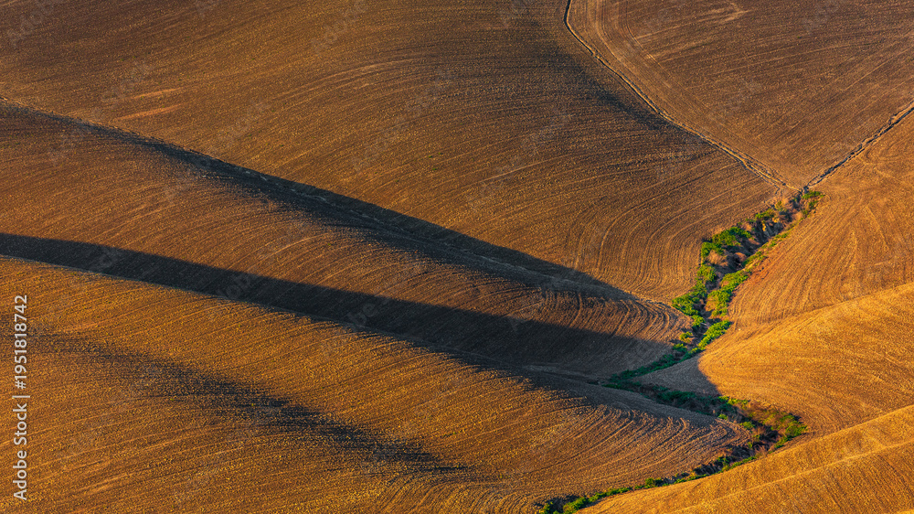 Fototapeta premium Rolling cultivated fields with shadows, Tuscany, Italy.