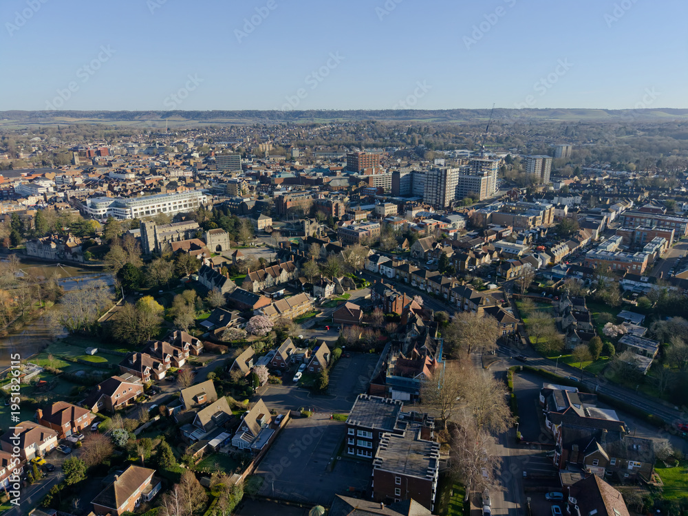 Obraz premium Panoramic view of Maidstone town on a beautiful sunny morning. High altitude aerial view of historic town and business center in Kent, UK. Quiet residential area with trees by the river Medway.