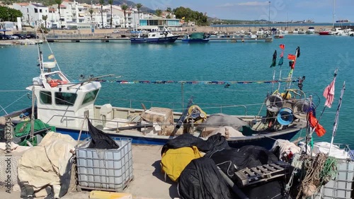 Fishing port of Las Casas de Alcanar in Catalonia, Spain. View of the boats with traditional fishing gear moored at the dock. Smooth camera movement: Track Left.