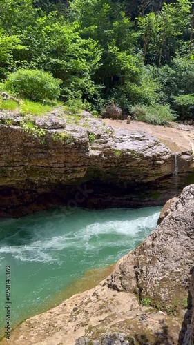 Majestic canyon with stunning turquoise and blue water flowing through. Mountain river, rocky cliffs, lush green forest on edges. Dynamic video of fast stream, rapids and waterfall motion.