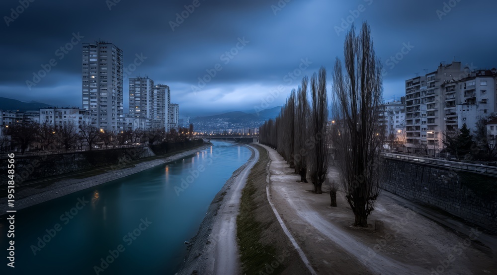 Obraz premium City with a river running through it. The river is dark blue and the sky is cloudy