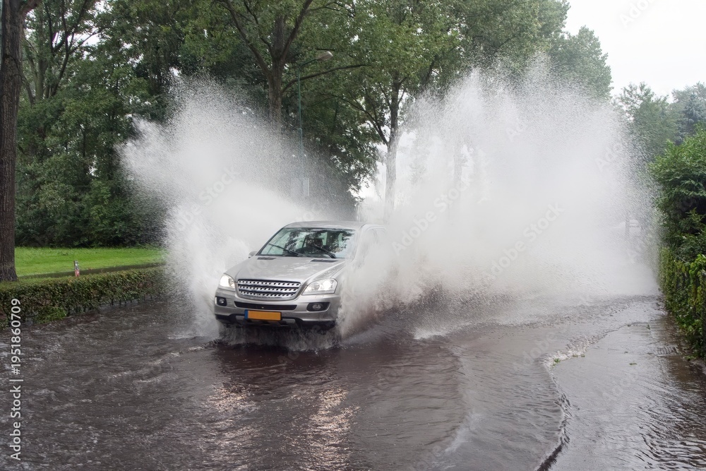 Obraz premium Car driving through a flooded street in the Netherlands