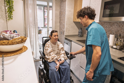 Caregiver assisting disabled woman in home kitchen