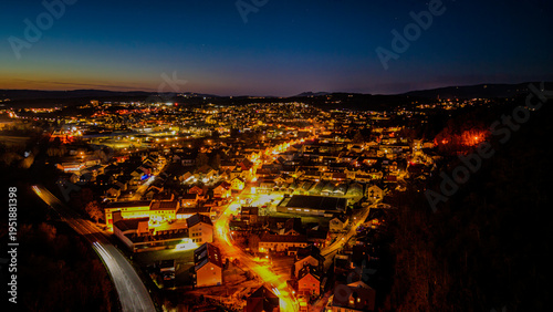 Blick über eine Stadt mit Lichtern in der Nacht und der Dunkelheit am Horizont