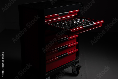 Open red tool chest with organized socket and ratchet tools in workshop