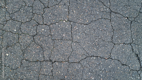 Close-up of cracked asphalt pavement texture
